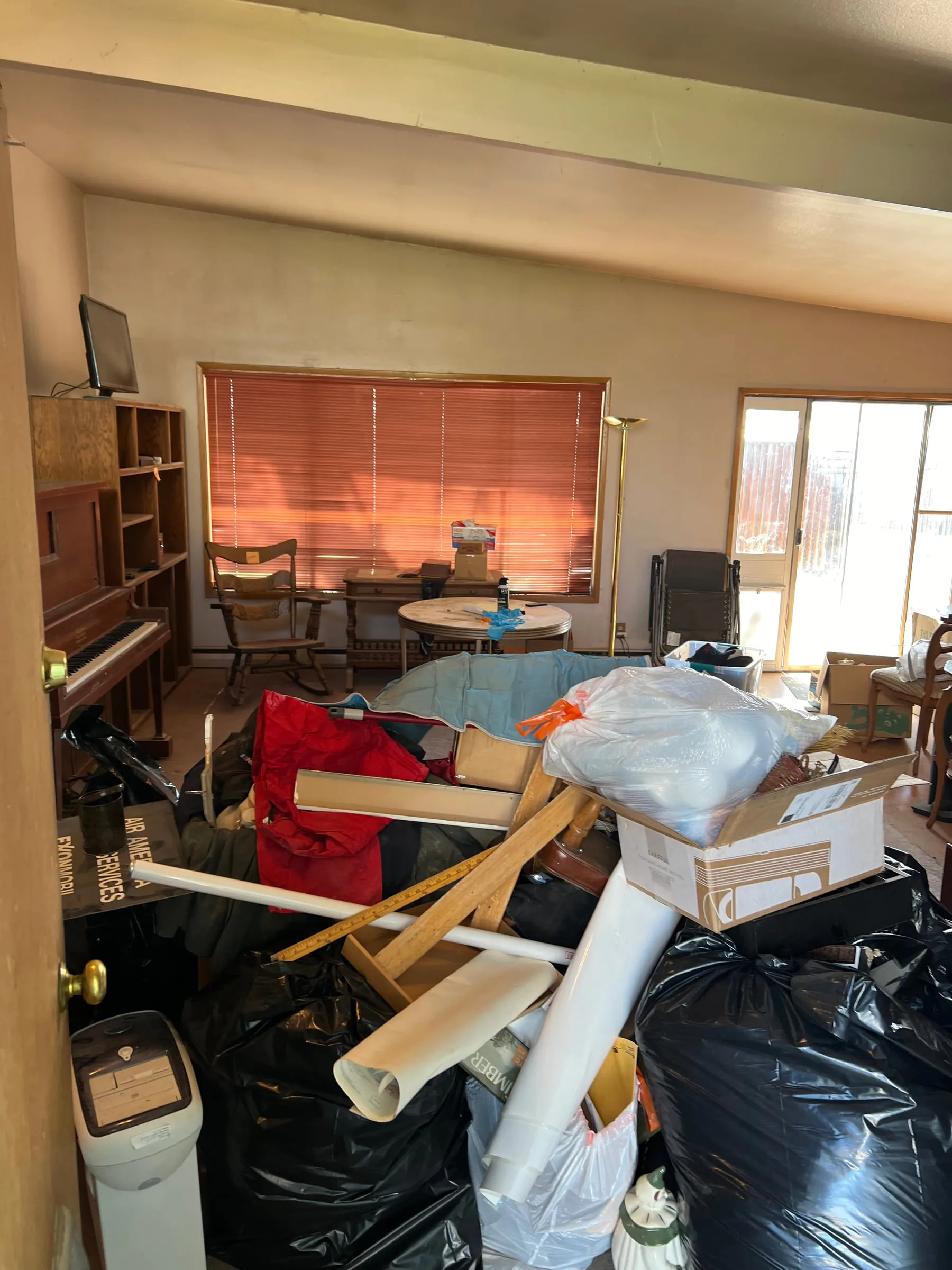 A living room packed with furniture and boxes before a full clear-out