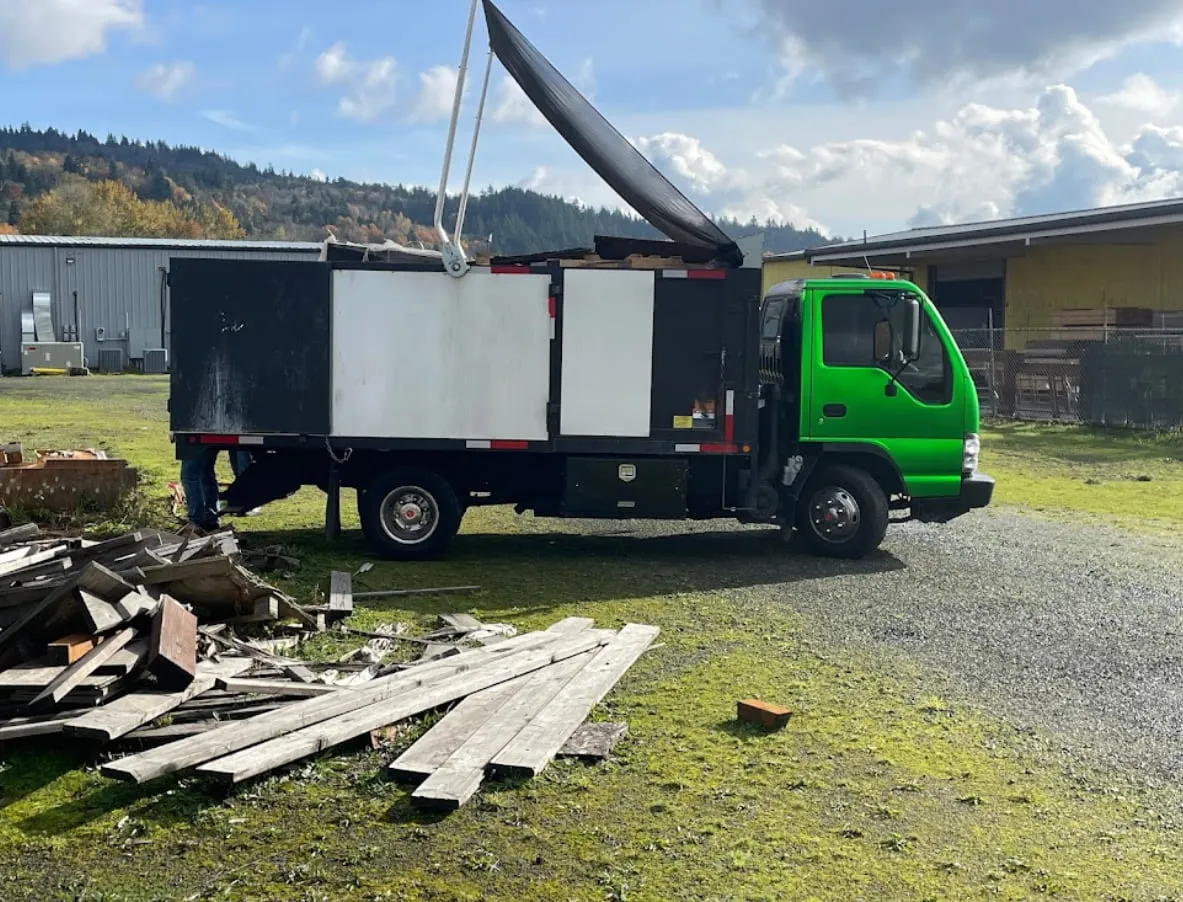 The truck parked on site beside a cleared pile of lumber