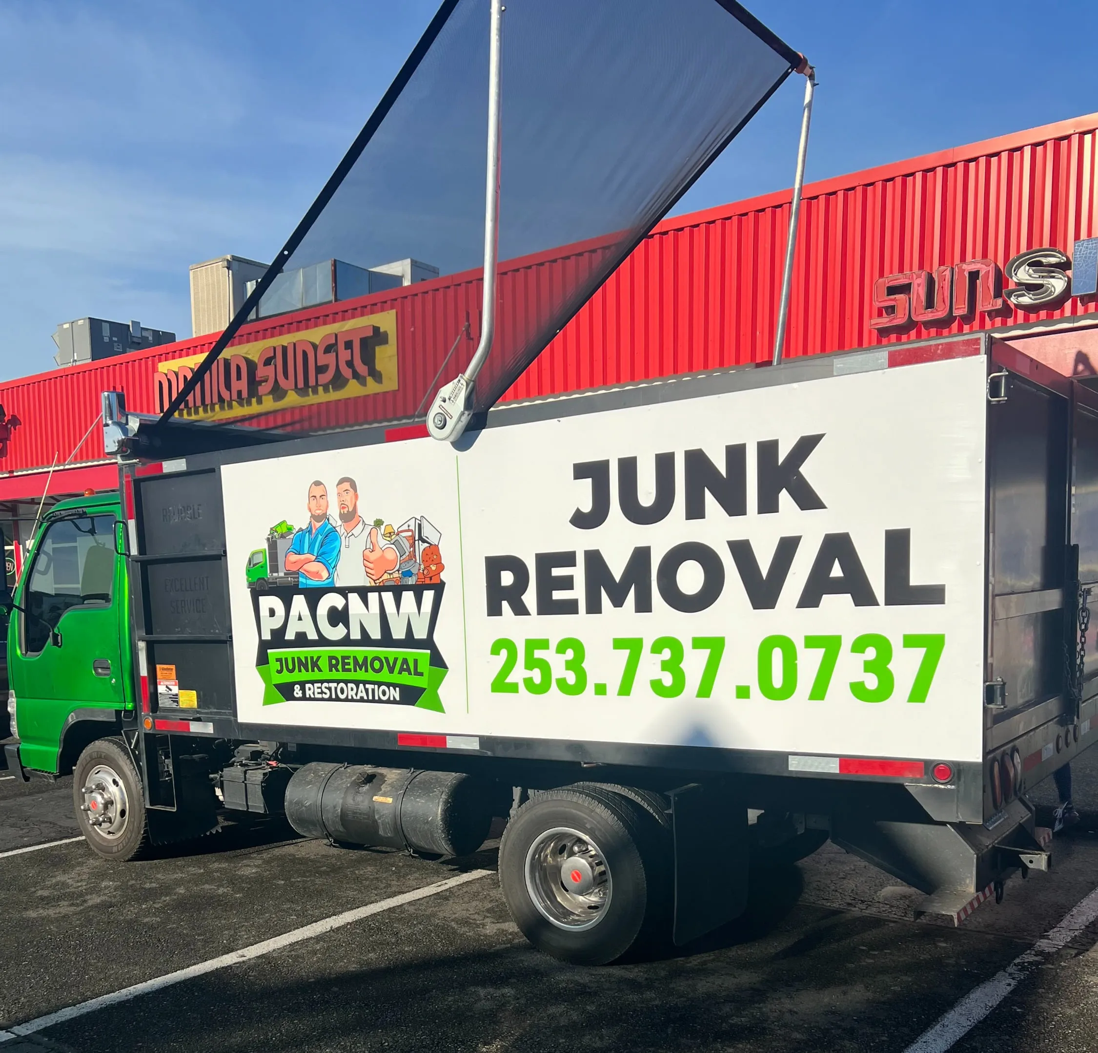 The PAC NW Junk Removal truck — a 20-yard dump truck with the company logo on the side